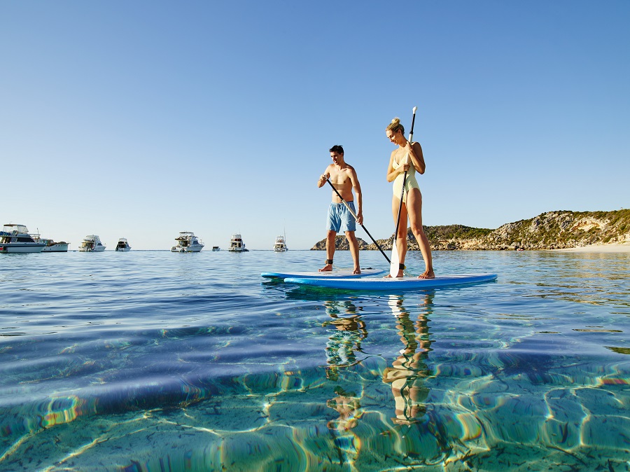 Couple using stand up paddle boards, Rottnest Island.